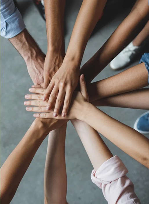 A diverse group of people placing their hands together